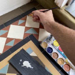 chip being filled and coloured on this Victorian tile in a hallway- Victorian tile chip and crack repair service